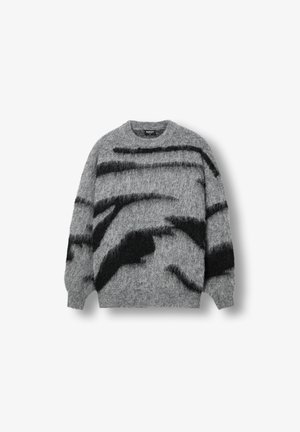 Sivi pleteni džemper s krznenom teksturom, odvažnim crnim apstraktnim prugama, okruglim izrezom i rebrastim manžitama i ivicom.