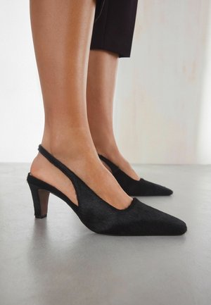 Mustat slingback-korkokengät, joissa on teräväkärkiset varpaat, valmistettu tekstuurimateriaalista, joissa on leikattuja sivuja ja kiiltävä korko.