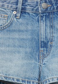 Short en jean bleu clair avec poches avant, passants pour ceinture, fermeture par boutons et détails de couture visibles.