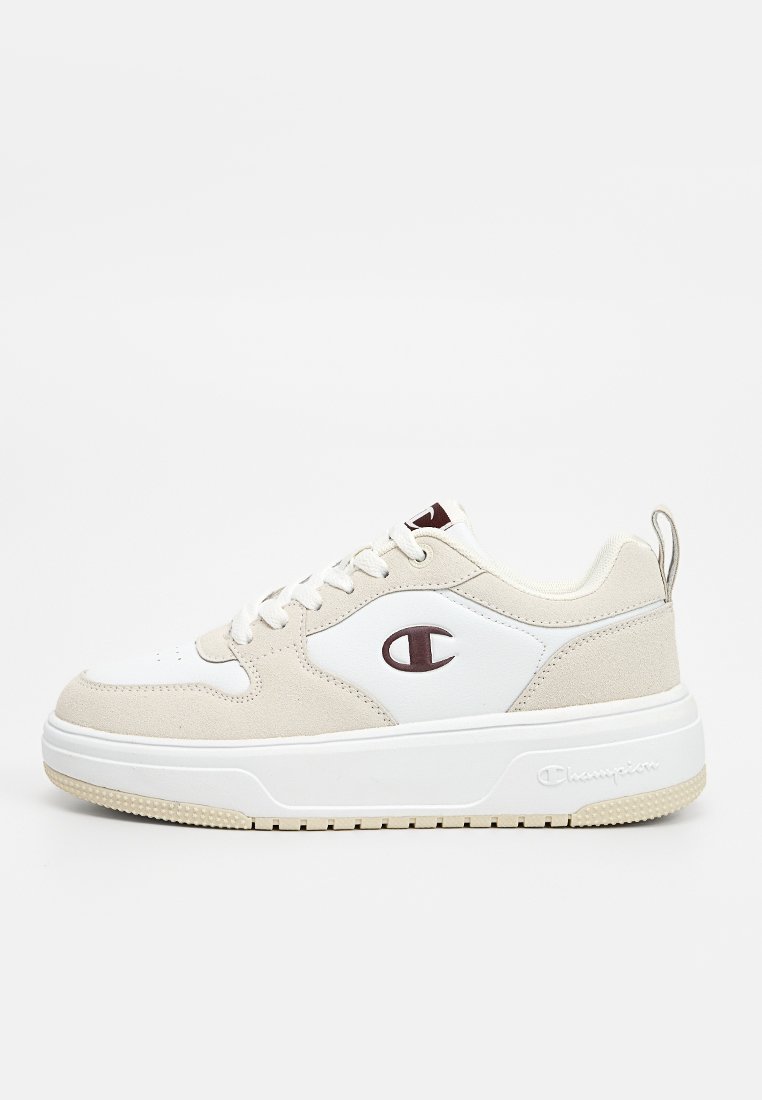 Zapatilla blanca y beige con parte superior de ante y cuero, puntera redonda, cierre de cordones y acento de logo; suela blanca gruesa con banda de rodadura texturizada en un tono claro de beige.