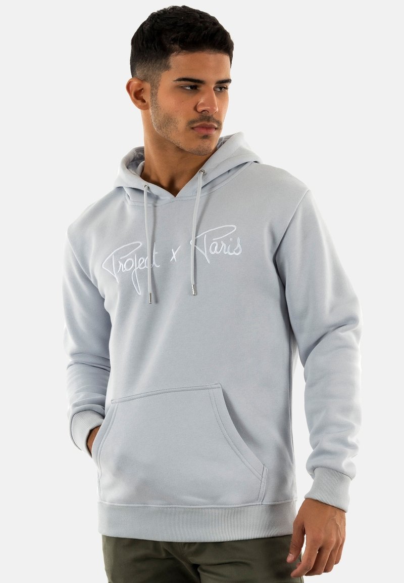 Hoodie grigio chiaro con tasca frontale, caratterizzato da testo ricamato bianco "Project x Paris", coulisse regolabile e polsini a costine.