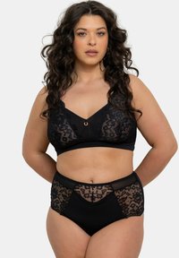 Brassière en dentelle noire et culotte haute avec des accents transparents et un détail en anneau doré à l'avant. Texture douce avec des motifs floraux.