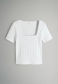 Biela pruhovaná blúzka s krátkym rukávom a štvorcovým výstrihom. Mäkkučký materiál, priliehavý strih a rovný lem. Žiadne ďalšie vzory ani akcenty.