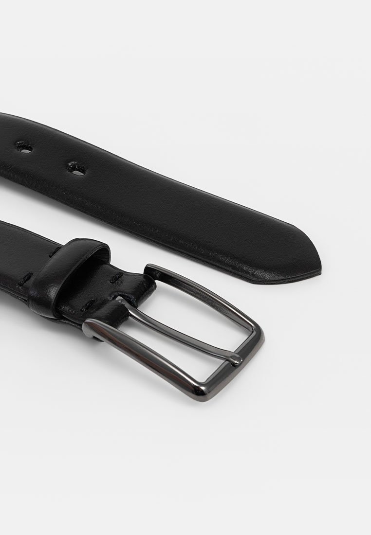 Ceinture en cuir noir avec une boucle en métal argentée. La sangle présente des trous pour l'ajustement et possède une texture lisse. Les extrémités sont coupées droites.