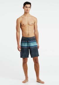 Mannen zwemshorts in navy met horizontale strepen in teal en roze. Heeft een tailleband met trekkoord en een textuurstof.
