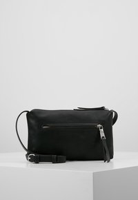 Borsa in pelle nera con superficie texturizzata, forma rettangolare, tasca anteriore con zip, tracolla regolabile e dettagli in metallo argentato.