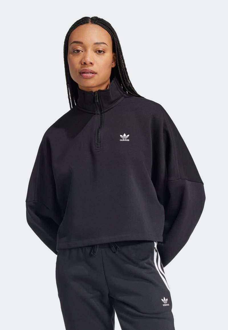 Must must ülikond, millel on kõrge krae, väike valge Adidas logo rinnal ja lõdva istumise disain.