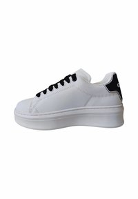 Sneaker bianco con suola spessa, lacci neri e accentuazione nera sul tallone. Presenta un materiale liscio e un design minimalista.
