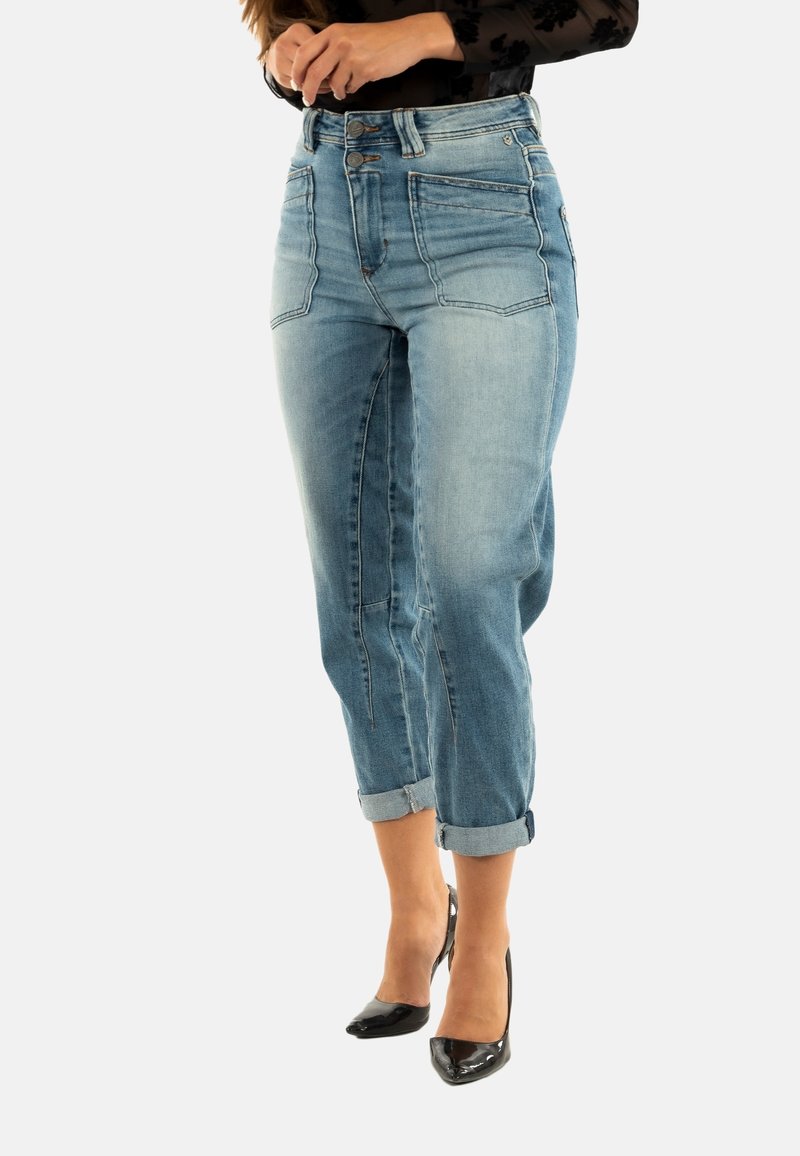 Jeans de tiro alto de color azul claro con puños enrollados, que cuentan con un diseño clásico de cinco bolsillos y un ligero desvanecimiento en las piernas.