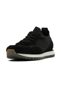Sneaker nera realizzata con un mix di materiali in mesh e suede, punta arrotondata, suola testurizzata e soletta bianca a contrasto. I lacci sono in evidenza.