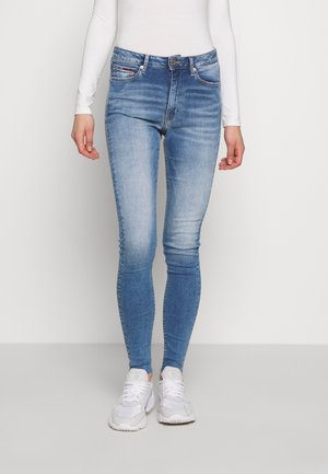 Jeans ajustados azules con un lavado desgastado, cinco bolsillos y un cierre de botón plateado. Presentan un ligero elastano y un acabado suave y limpio.