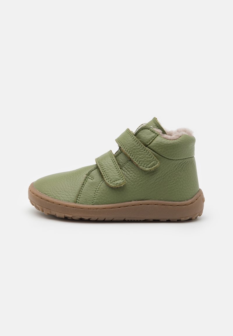 Botte vert en cuir pour enfants, semelle marron, deux sangles Velcro et doublure intérieure légère en fourrure.