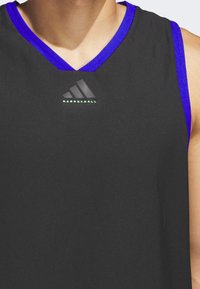 Black basketball jersey with a V-neck design. Features purple accents on the collar and armholes. Displays the Adidas logo in black and green.