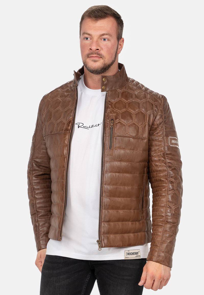 Bruine leren jack met een hexagonaal patroon, geborduurde secties, een hoge kraag, twee ritszakken en een logo op de mouw.