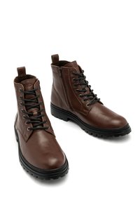 Brązowe skórzane botki sięgające kostki o teksturowanym wykończeniu, z przodem zapinanym na sznurowadła, bocznym zamkiem błyskawicznym oraz solidną gumową podeszwą zapewniającą przyczepność.