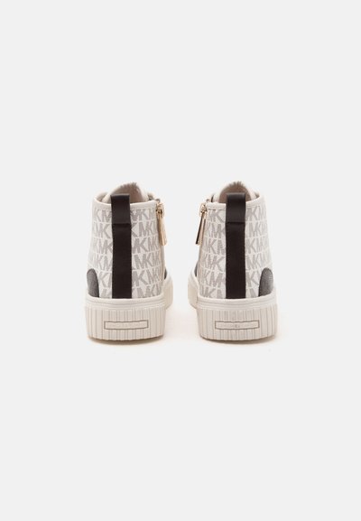Ζευγάρι μπεζ και καφέ sneakers ψηλού τύπου με μοτίβο λογότυπου, μαύρη κάθετη λωρίδα στη φτέρνα και λευκές λαστιχένιες σόλες με ετικέτα ονόματος μάρκας.