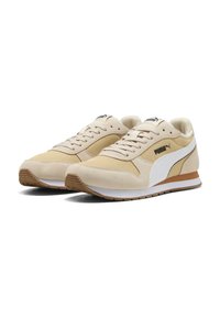 Beige løbesko med en kombination af ruskind og mesh, der har et hvidt logo, en tekstureret sål og en let polstret krave.