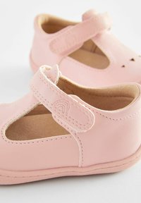 Helle rosa Leder-Mary-Jane-Schuhe mit runder Zehenform, ausgeschnittenem Design, Klettverschluss und subtilen Stichdetails. Flache Sohle.