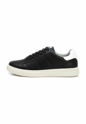 Zapatillas de cuero negras con acentos blancos, diseño con cordones, forro gris claro y suela de goma texturizada. Silueta simple y moderna.