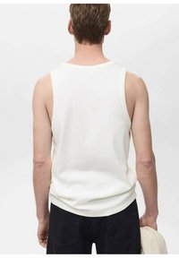 Witte mouwloze tanktop van ribstof, met een ronde halslijn en een ontspannen pasvorm, gecombineerd met donkere jeans.
