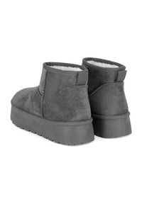 Botines de ante gris con un forro suave de piel, suela plana texturizada y detalles de costuras contrastantes a lo largo de las costuras.