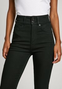 High-waisted black jeans made of denim, featuring a two-button closure, front pockets, and a slim fit design. Smooth texture, no patterns.