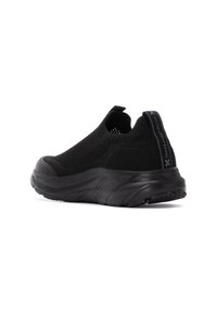 Zapatillas negras tipo slip-on con parte superior de punto texturizado, lengüeta en el talón y suela de goma gruesa diseñada para comodidad y soporte.