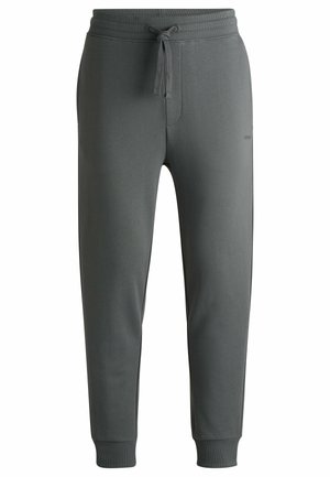 Pantalons de jogging gris avec une taille à cordon, jambes fuselées et poignets côtelés. Tissu doux et lisse avec un branding subtil sur le côté.