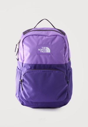 Mochila North Face bicolor morada con bolsillo frontal con cremallera, bolsillos laterales de malla y asa superior para llevar sobre fondo blanco.