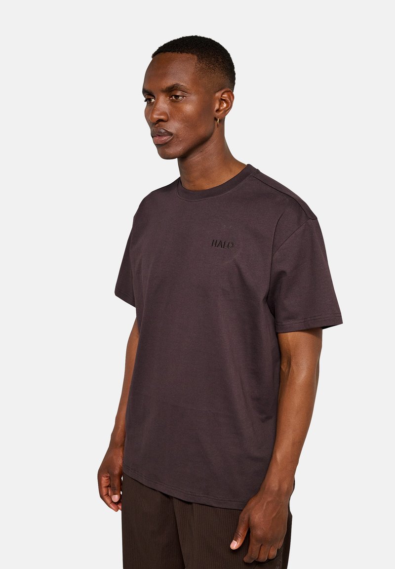 Ciemnobrązowa koszulka z krótkim rękawem wykonana z miękkiej bawełny, z subtelnym haftowanym logo "HALO" na piersi. Prosty, luźny krój.