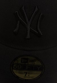 Gorra New Era 59FIFTY negra que presenta un logo en relieve de los New York Yankees, un diseño estructurado y una pegatina brillante del tamaño en la parte inferior del ala.