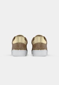 Braune Sneaker mit Muster und goldenen Akzenten, weißen Sohlen und einer strukturierten Oberfläche. Sie verfügen über eine abgerundete Form und einen gepolsterten Knöchelkragen.