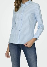 Light blue button-up shirt with vertical stripes, long sleeves, and a classic collar. Fabric appears smooth with a slightly fitted silhouette.