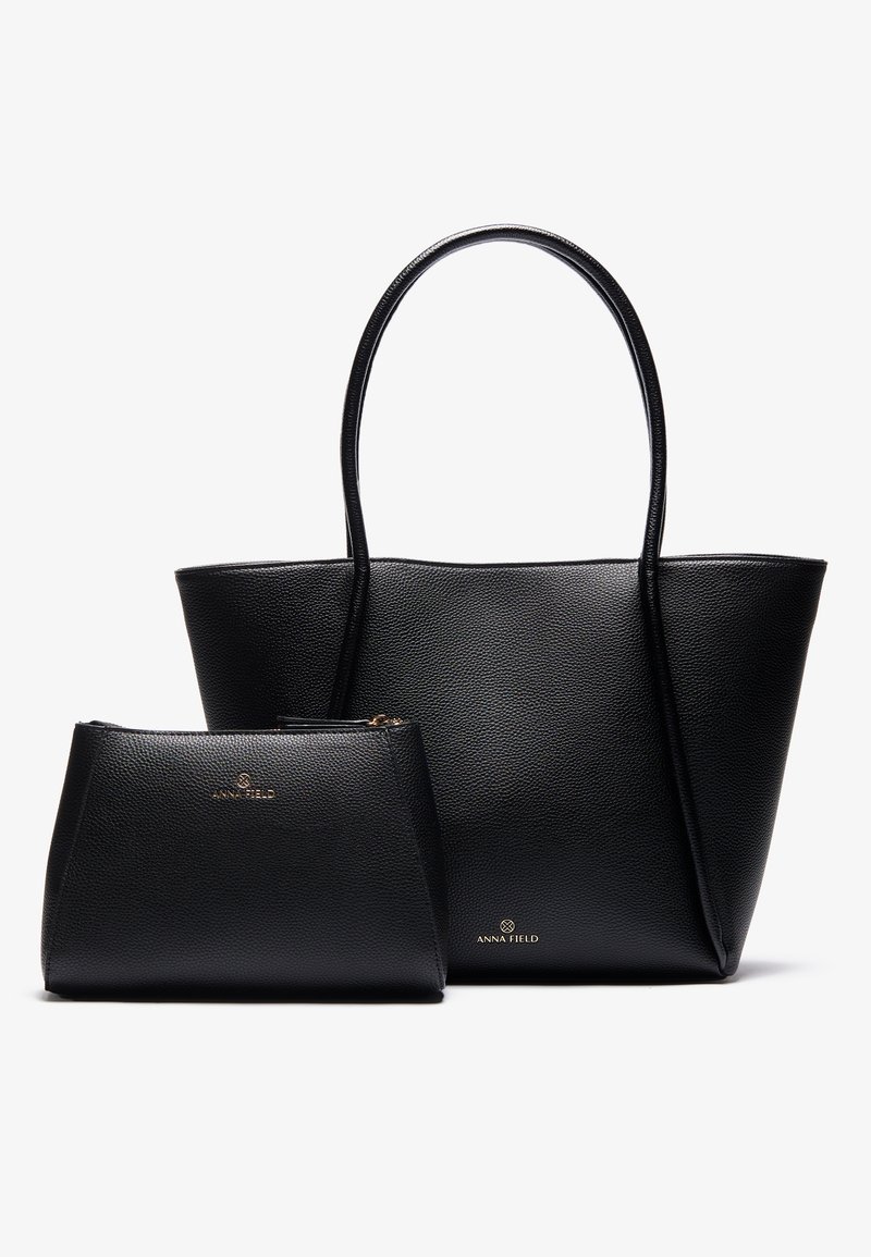 Svart strukturerad toteväska med två handtag, med pebblad textur och en mindre matchande påse med dragkedja. Guldfärgade logodetaljer.
