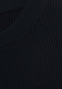Tejido de punto negro con canalé, que presenta un escote redondo y una textura sutil, con líneas verticales espaciadas uniformemente por toda la superficie.