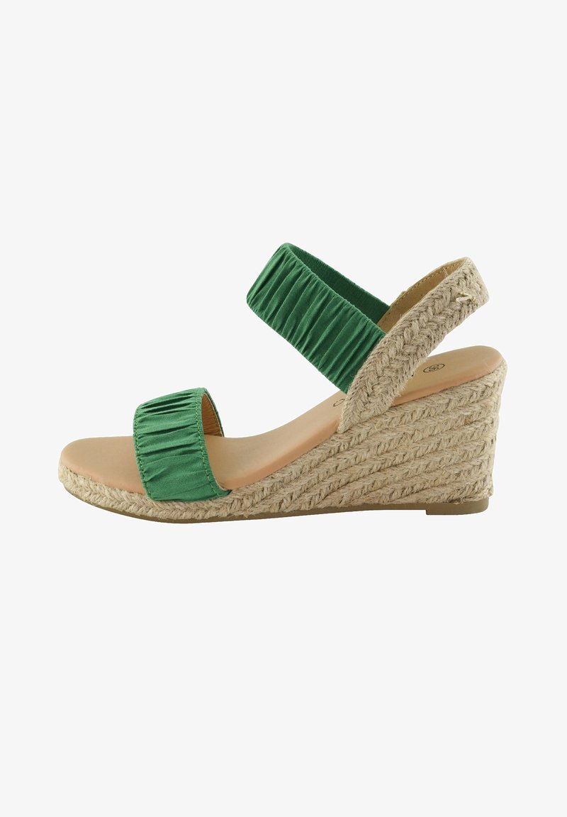 Sandale compensée verte avec une tige en tissu côtelé et une semelle en jute de style espadrille. Elle présente une large bride à la cheville et une semelle intérieure lisse.