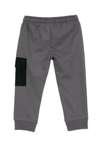 Pantalon de jogging gris en tissu doux, doté d'une ceinture élastique, de poignets côtelés et d'une poche cargo noire sur la jambe gauche.
