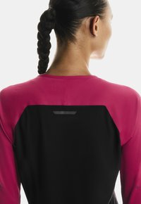 Dug rukav s rozom i crnom paletom boja, s teksturiranom tkaninom, reflektirajućim detaljem na poleđini i uskim krojem.