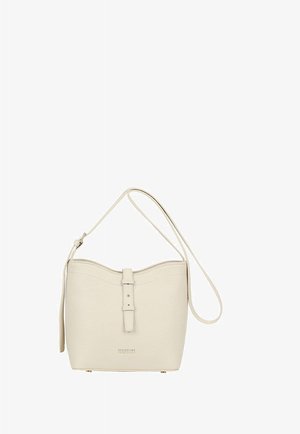 Sac seau de couleur crème avec bandoulière ajustable, surface texturée et détail de boucle à l'avant sur fond blanc.