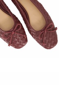 Burgundy woven leather ballet flats with a rounded toe and decorative bow detail at the front. Smooth interior lining and flexible sole.