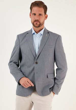 Sininen ja valkoinen ruudullinen bleiseri, jossa on yksi nappisuljenta, lovireunaiset kaulukset, kaksi etutaskua ja huomaamaton logoyksityiskohta kauluksessa.