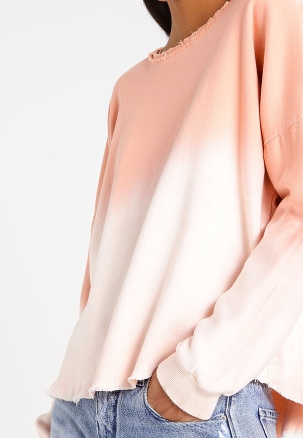 Lichtgewicht, dip-geverfde sweatshirt in koraal en wit. Voorzien van een rafelige halslijn en zoom, met omgeslagen mouwen. De stof heeft een zachte textuur.