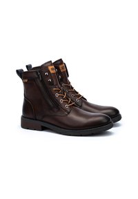 Bottes en cuir marron à la cheville avec fermeture à lacets et zip. Présente une finition texturée, des accents marron contrastants et une semelle robuste.