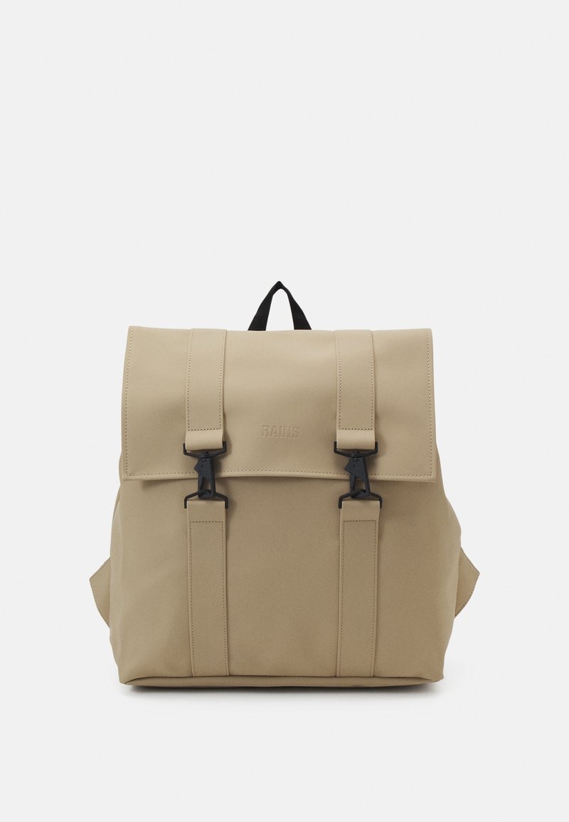 Sac à dos beige avec un rabat fermé par deux fermoirs noirs et des bretelles assorties, avec une petite poignée noire sur le dessus.