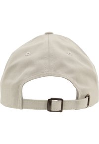 Beige katoenen honkbalpet met een gebogen rand, verstelbare achterkant en gestikte details op de stof. Minimalistisch ontwerp.