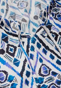 Baumwollstoff mit einem lebendigen geometrischen Muster in Blau-, Schwarz- und Weißtönen. Weiche Textur und leichtes Design, geeignet für Kleidung.