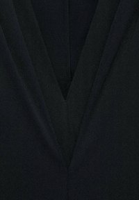 Tissu noir présentant un design à col en V profond avec un superposition de panneaux, une texture lisse et un léger brillant visible à la lumière.