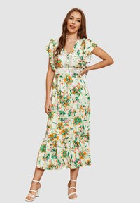 Vestido maxi con estampado floral que presenta un fondo blanco, flores en verde, naranja y rosa, mangas con volantes y un acento en la cintura con un diseño texturizado.
