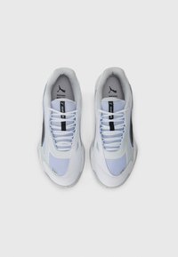 White athletic shoes with mesh and synthetic materials, featuring light blue accents, black logo, and a ridged sole design.