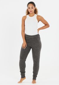 Light gray ribbed tank top paired with dark gray jogger pants, featuring a soft texture and fitted cuffs at the ankles.